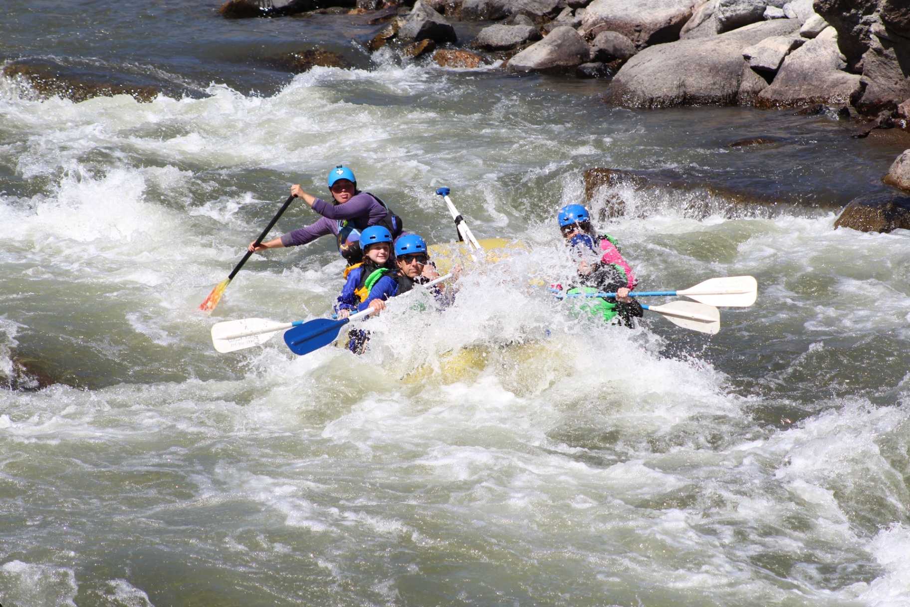 Wolfpack raft punching through a whitewater wave on the Arkansas River